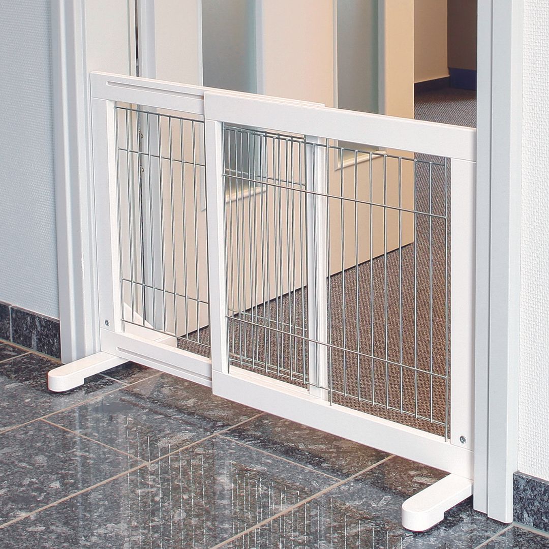 A small dog relaxing comfortably behind a stylish white wooden pet barrier with a clear varnish finish